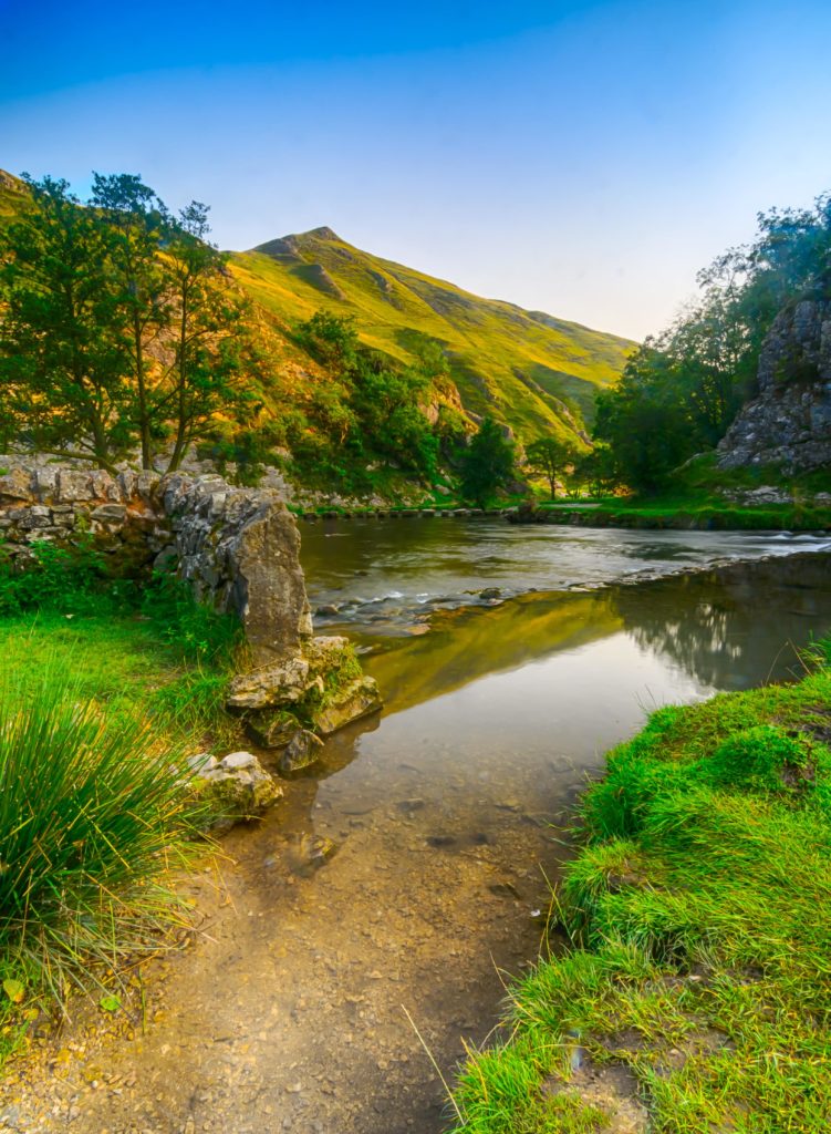 A beautiful view of the river Dove and stepping stones in the distance at Dovedale in the English Peak District
